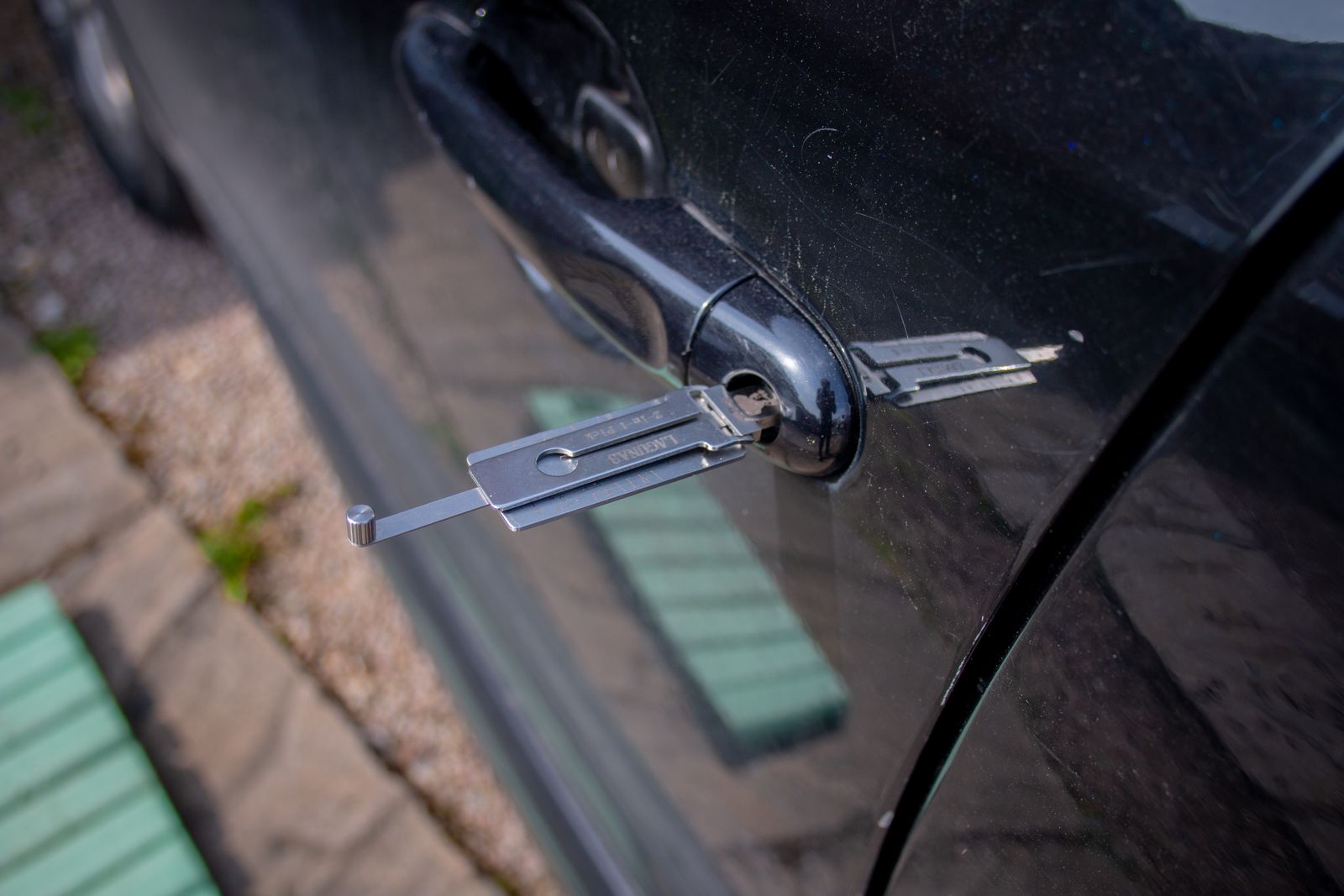 A locksmith’s tool opening a car door lock