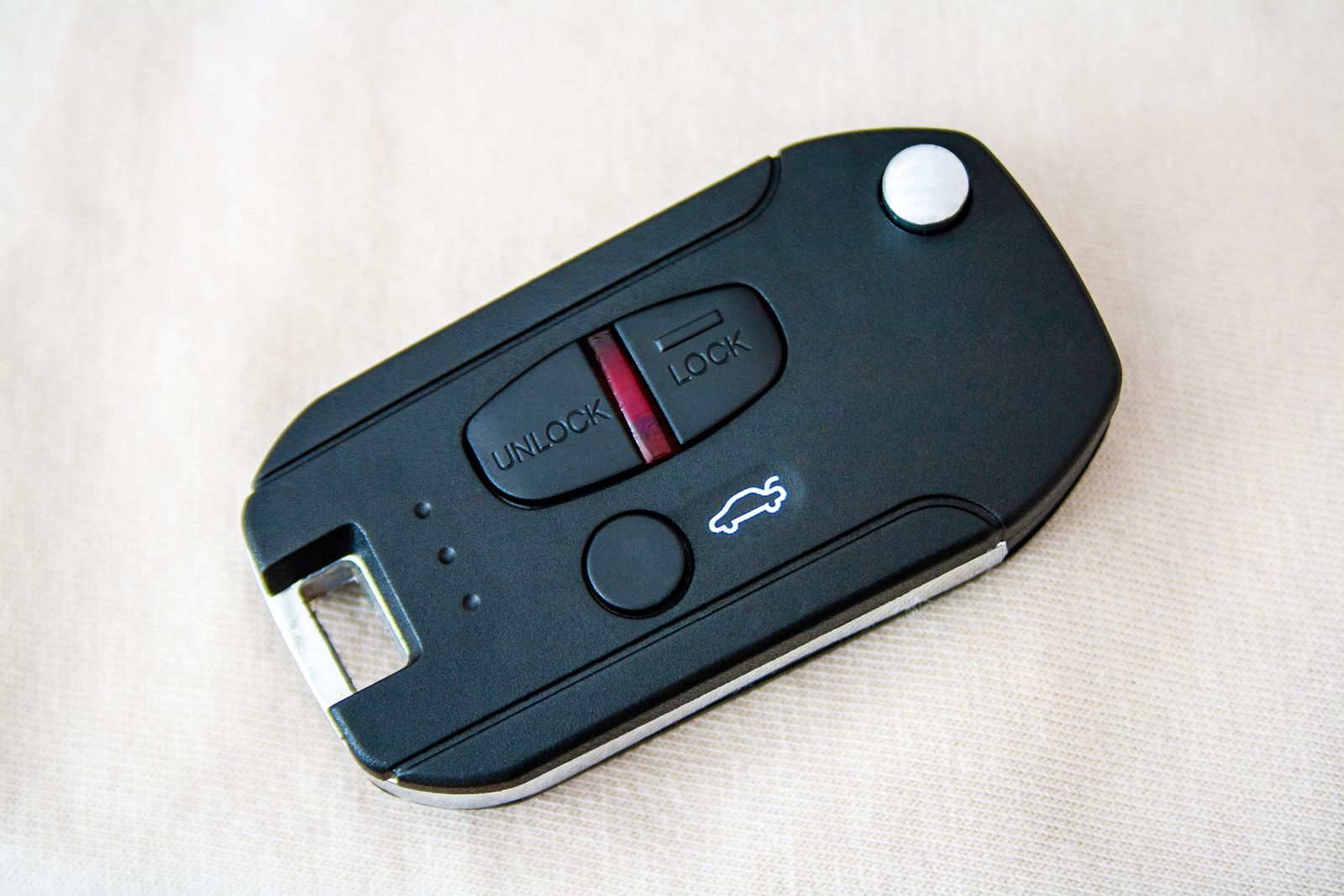 A black flip-style car key with remote buttons