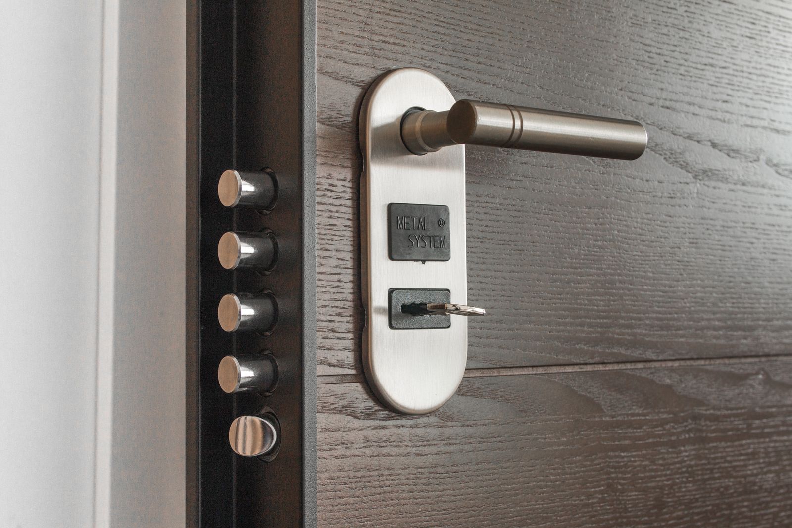 A deadbolt and handle on a dark door