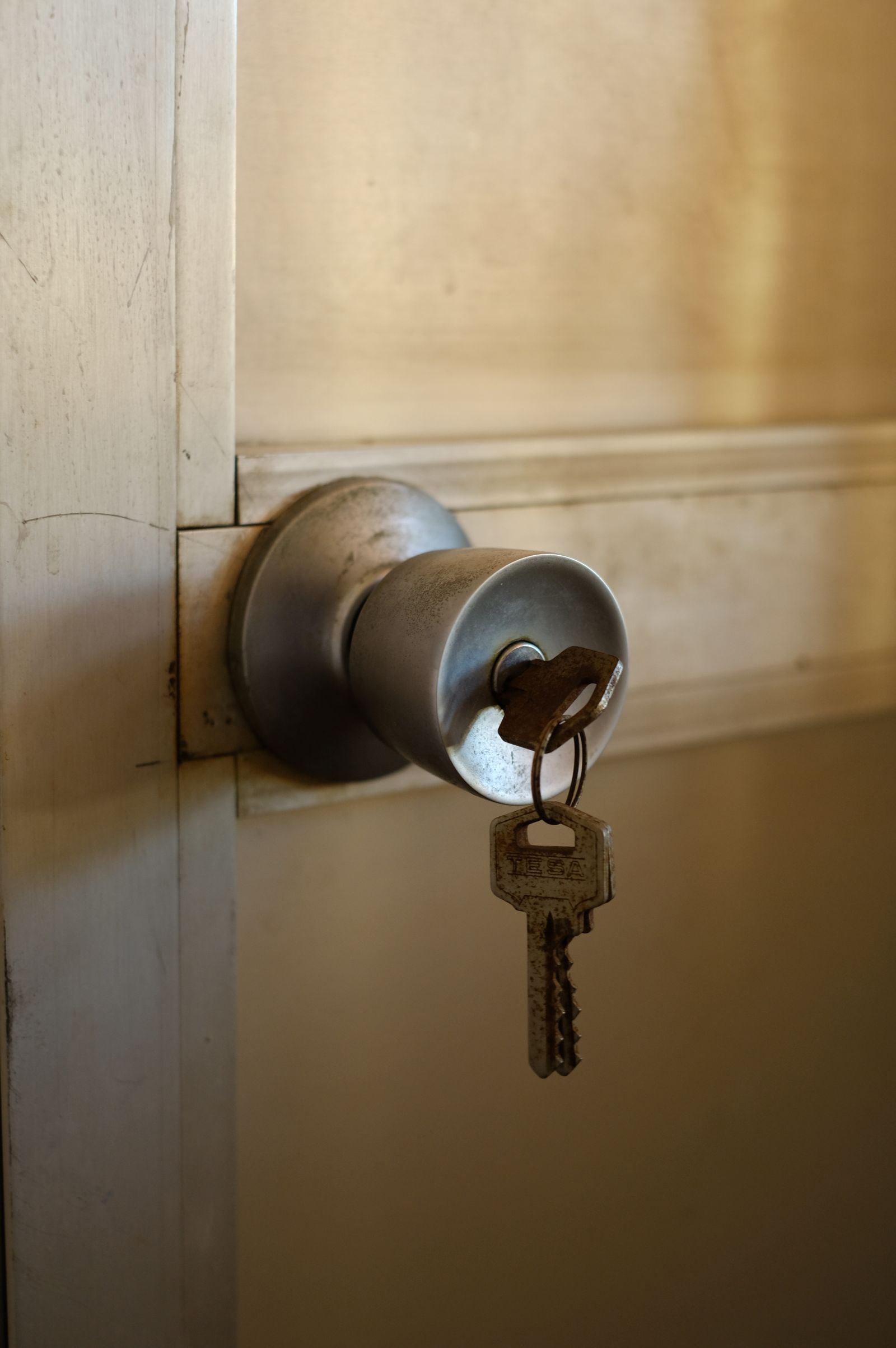 A key left in the lock of a brass doorknob