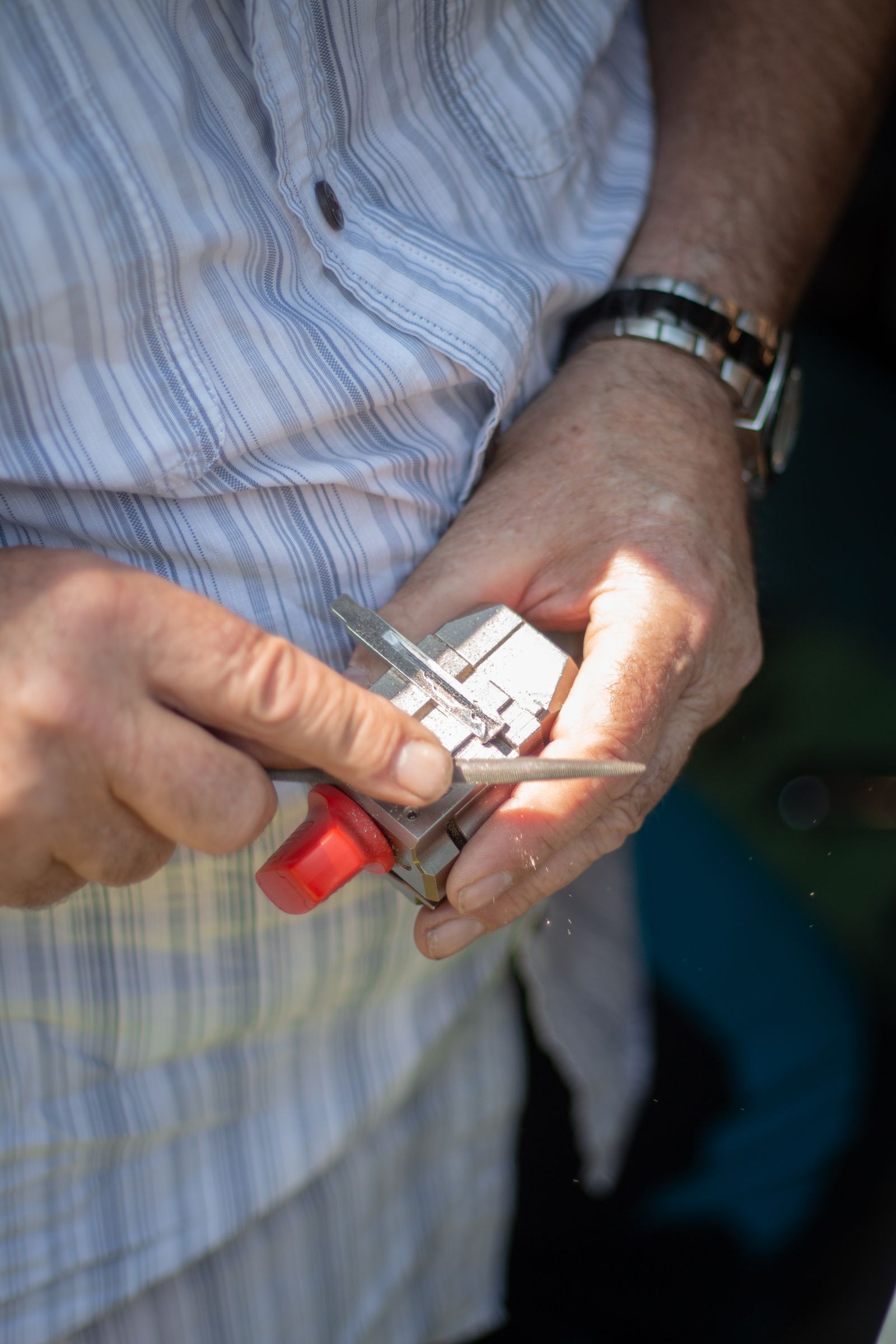 A man filing a key blade by hand